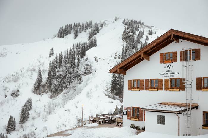Blick auf das alte Wallberghaus und die schneebedeckten Berge