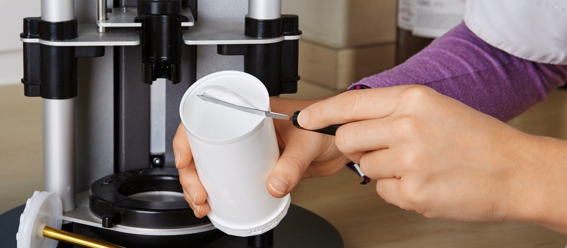 Im Labor wird eine Salbe in einen Tiegel abgefüllt.