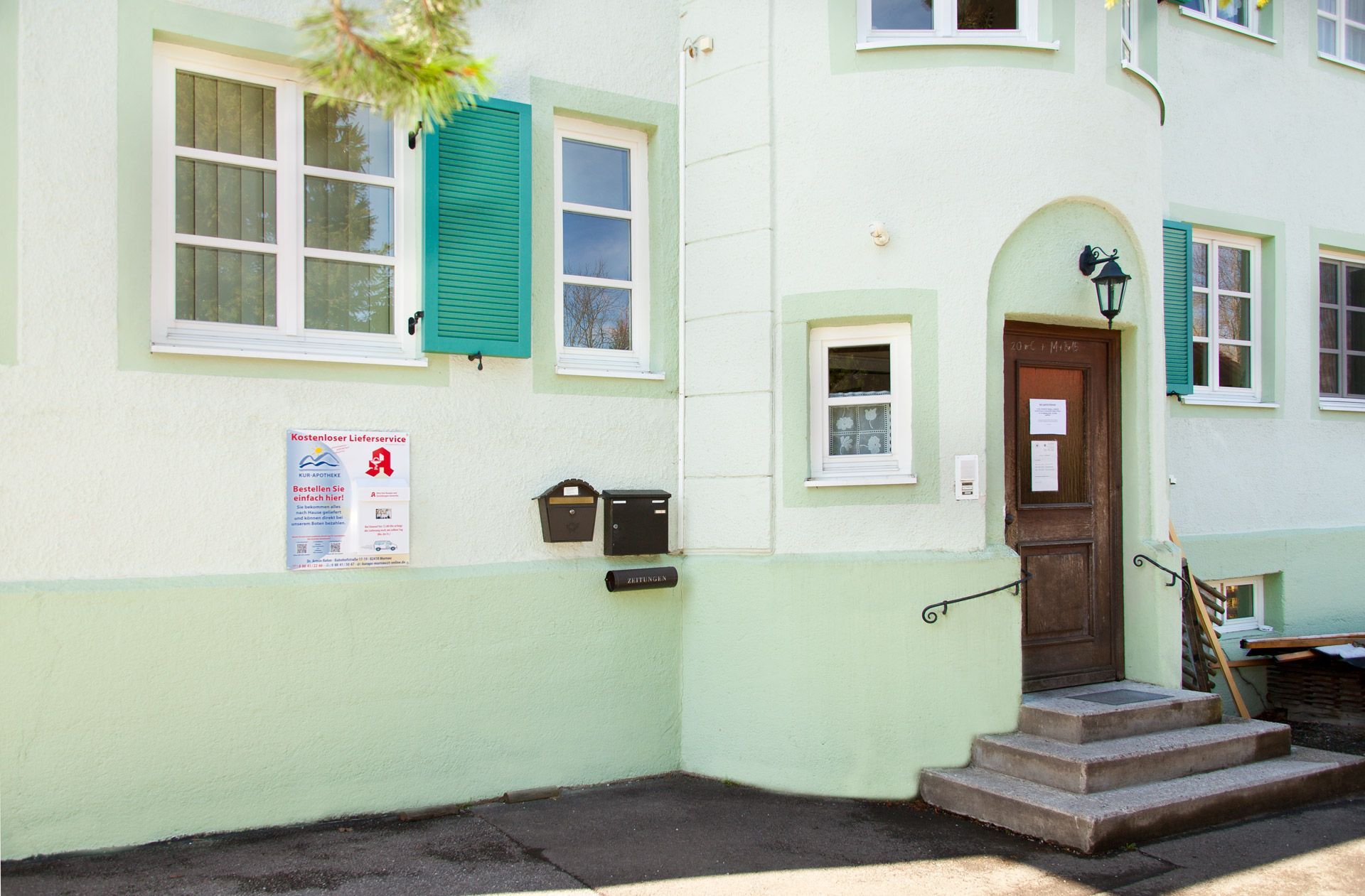 Eingang und Apotheken-Briefkasten der Praxis Hausarzt Oberland liegen an der Gebäudeseite.