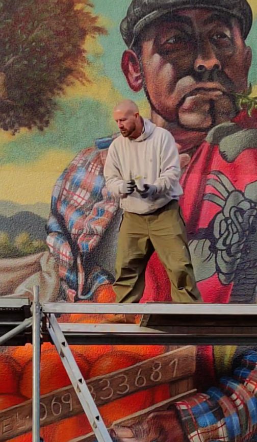 Kuenstler Drew Camell bei den Graffitiarbeiten auf dem Geruest