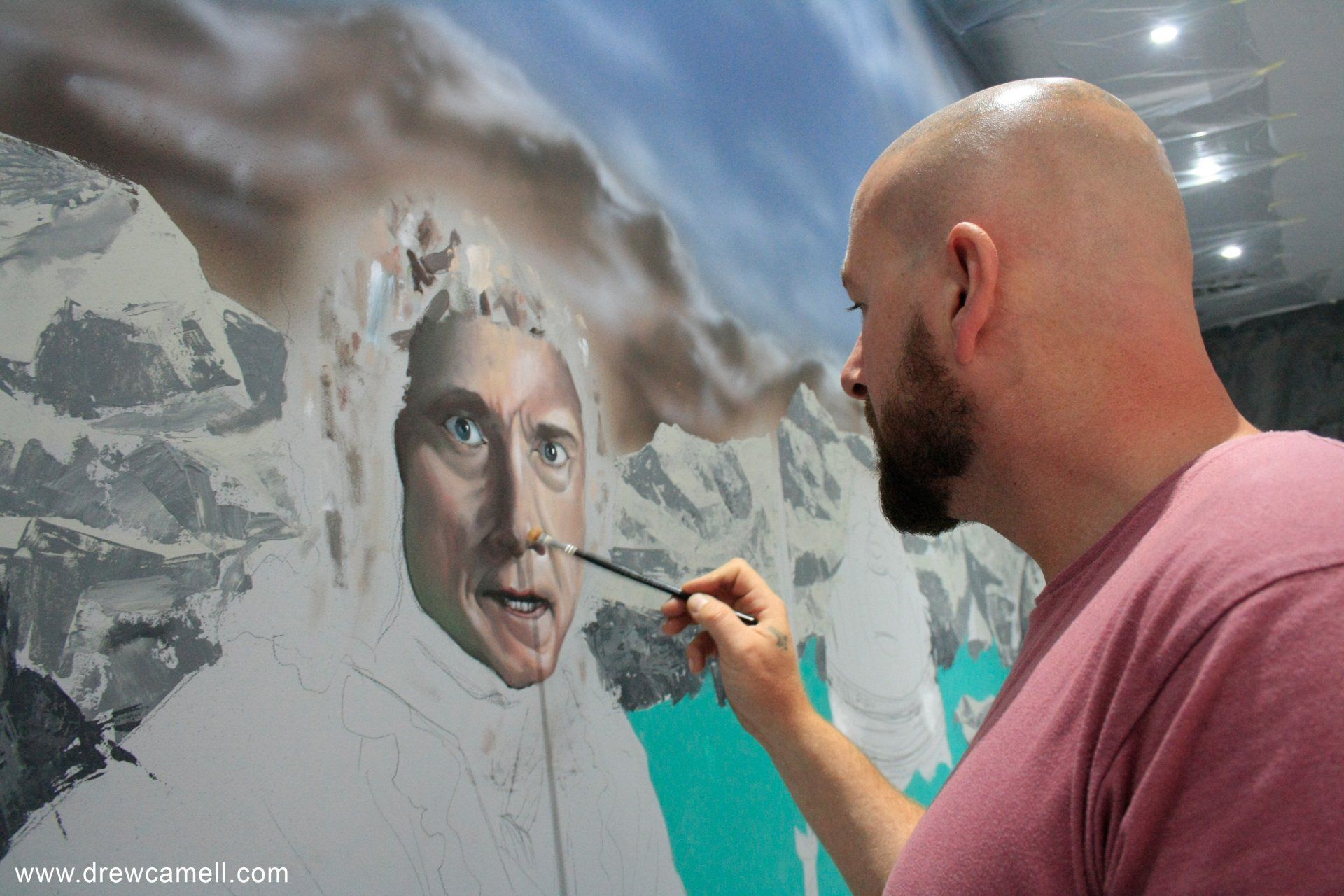 Künstler Drew Camell malt an einem Wand Portrait eines großen Aufragsgemaeldes