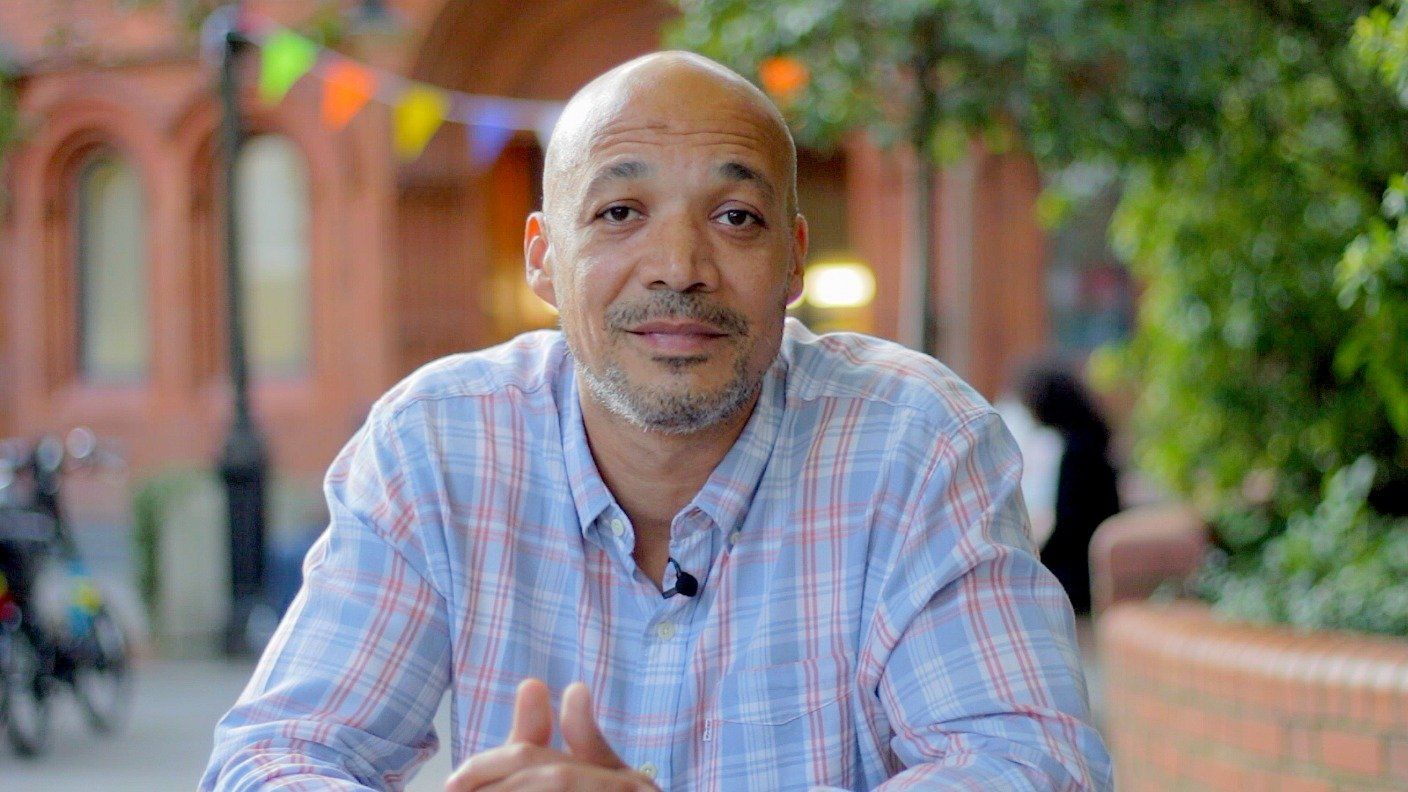 Bald man in shirt sat in a park