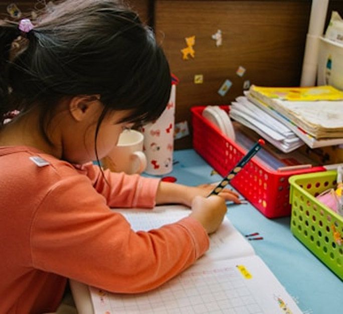 A young girl doing homework at a desk.
