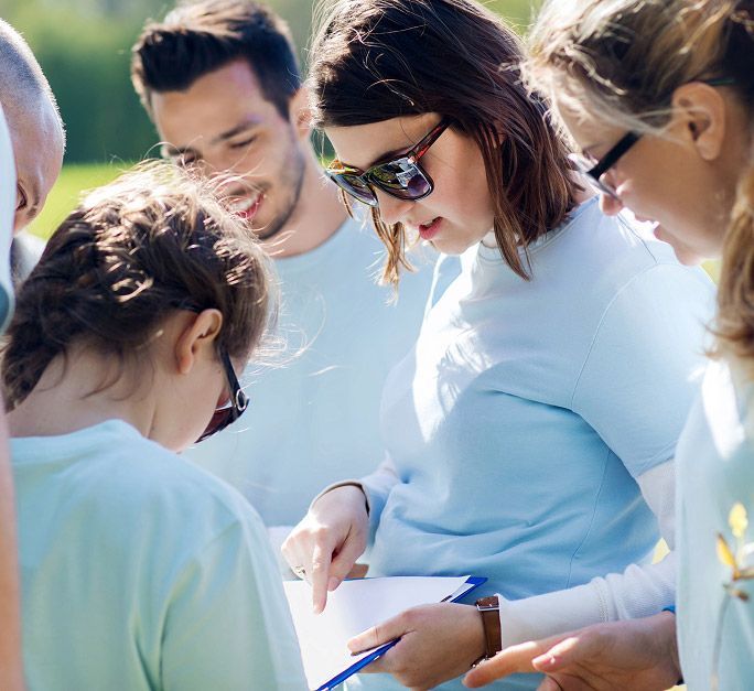 A team of young volunteers looking at a clipboard.