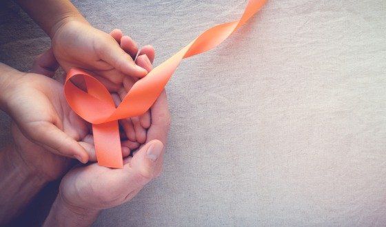 a pair of hands holding an awareness ribbon