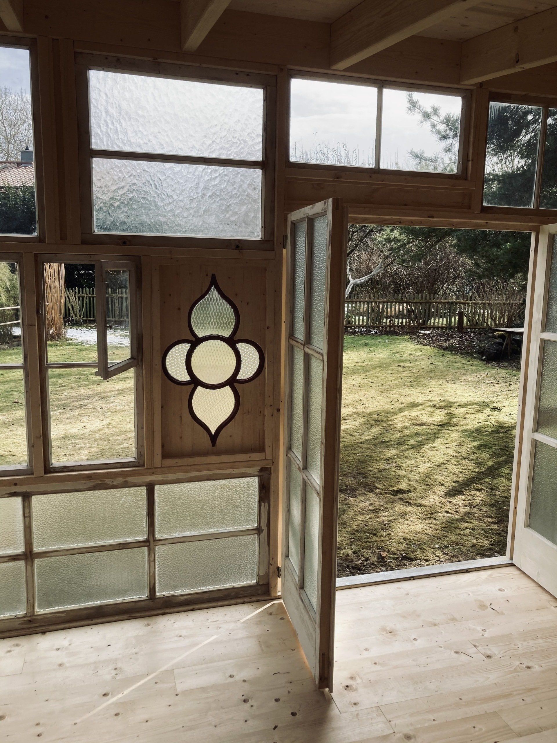 Innenansicht durch historische Fenster eines Gartenhauses im Chiemgau