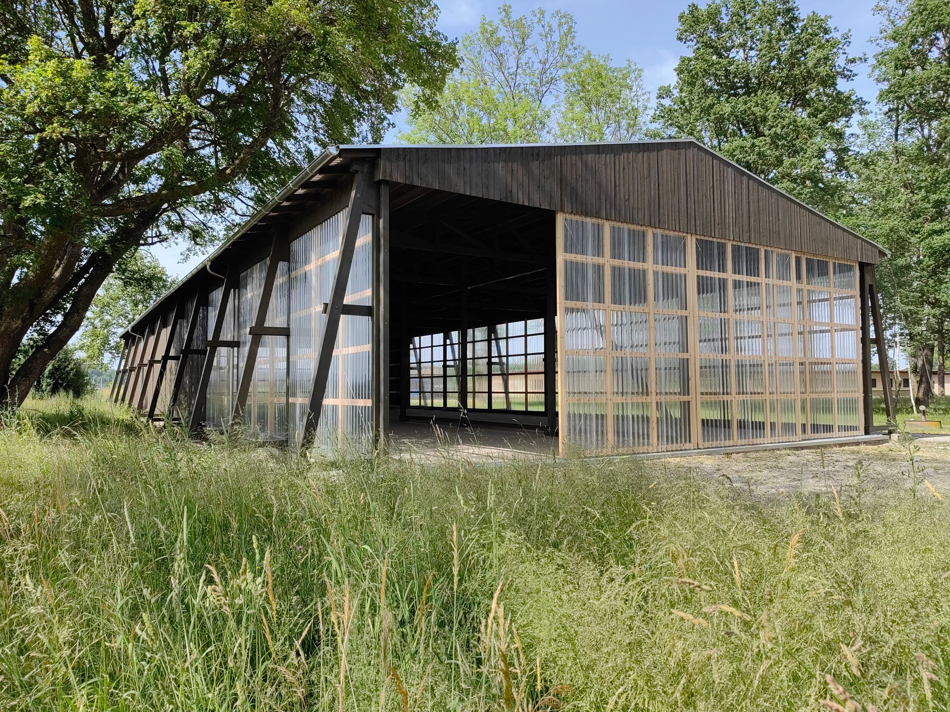 Seitlicher Blick auf das modernisierte Hallengebäude in ländlicher Umgebung mit Erhalt der Struktur, gebaut in Bad Aibling durch Zimmerei bauwerk singer