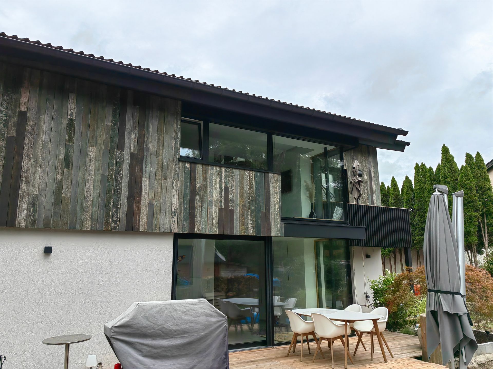 Moderne Haussanierung mit Holzfassade und Balkon, ausgeführt von Zimmerei bauwerk singer in Rosenheim