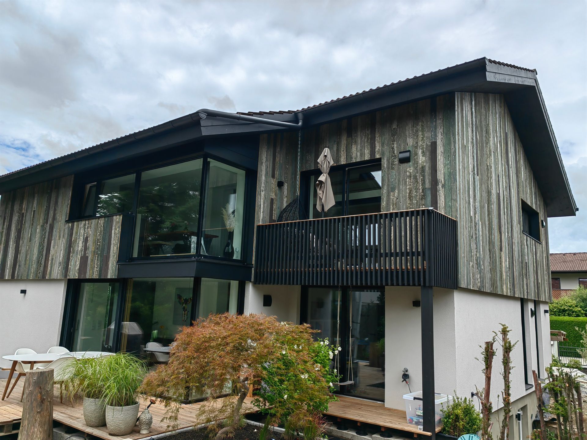 Zimmerei Projekt mit Holzfassade aus Vintage Holz und Balkon in Bad Aibling von bauwerk singer