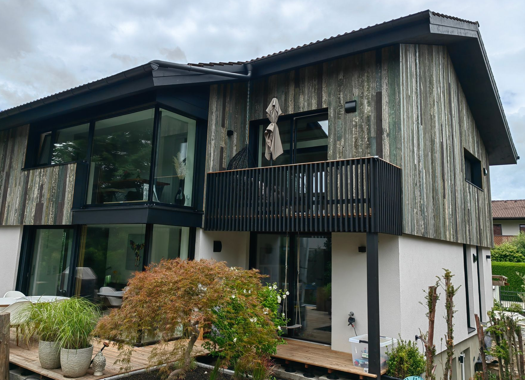 Individuelle Holzfassade mit Balkon und moderner Architektur im Raum Bad Aibling