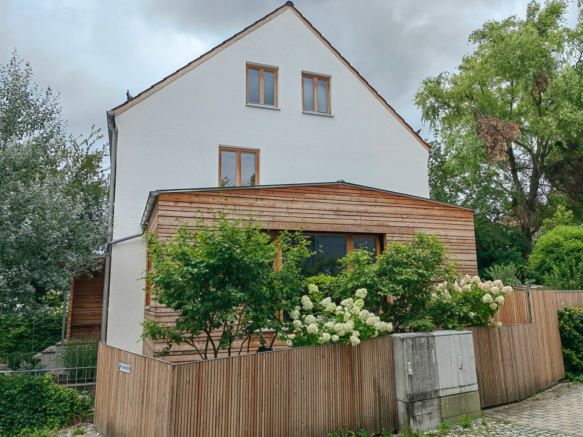 Harmonisch integrierter Holz-Anbau mit vertikaler Lärchenverschalung - nachhaltige Erweiterung am Bestandshaus in Rosenheim