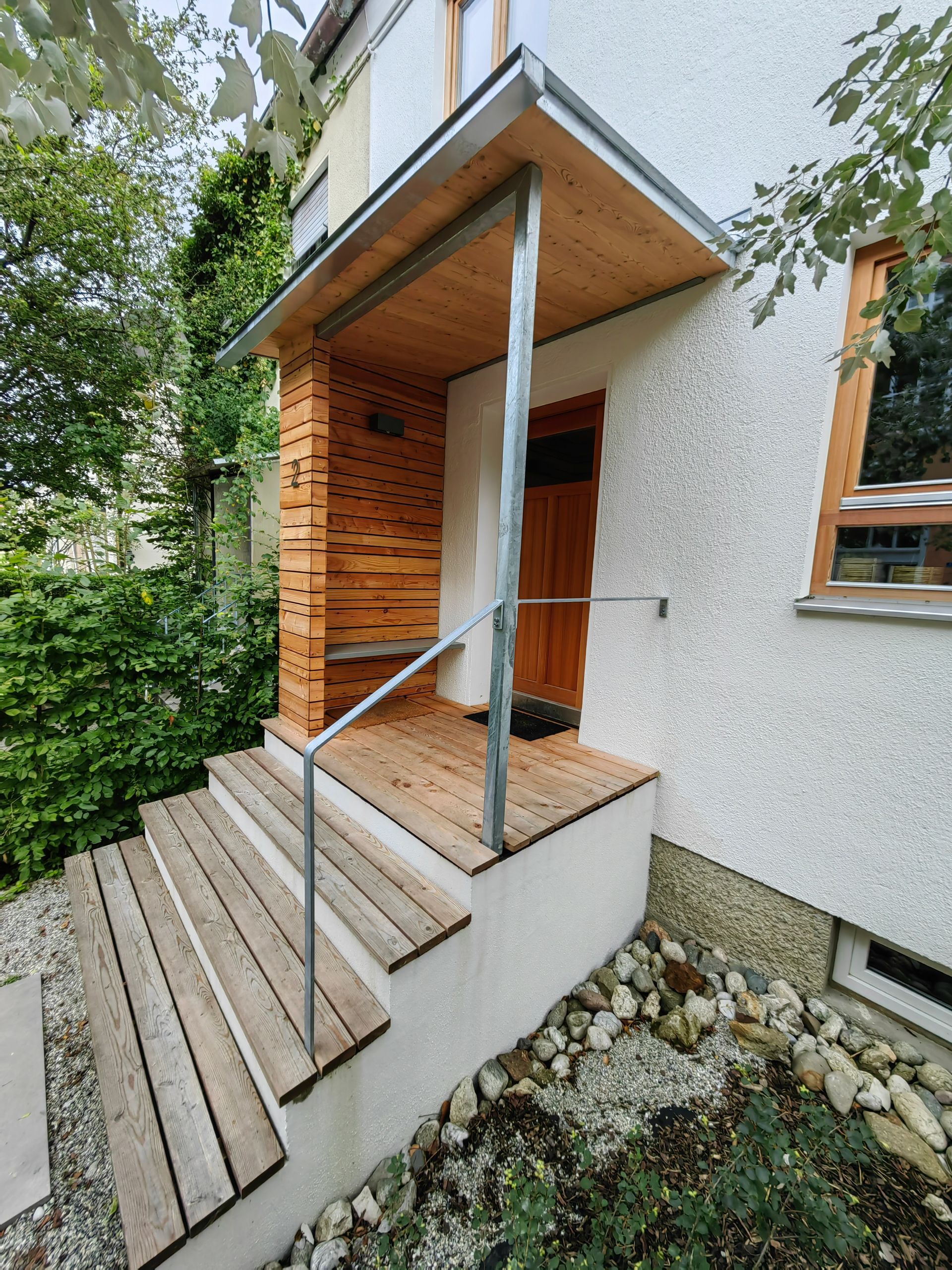 Moderner Eingangsbereich aus Lärchenholz in Rosenheim gebaut von bauwerk singer