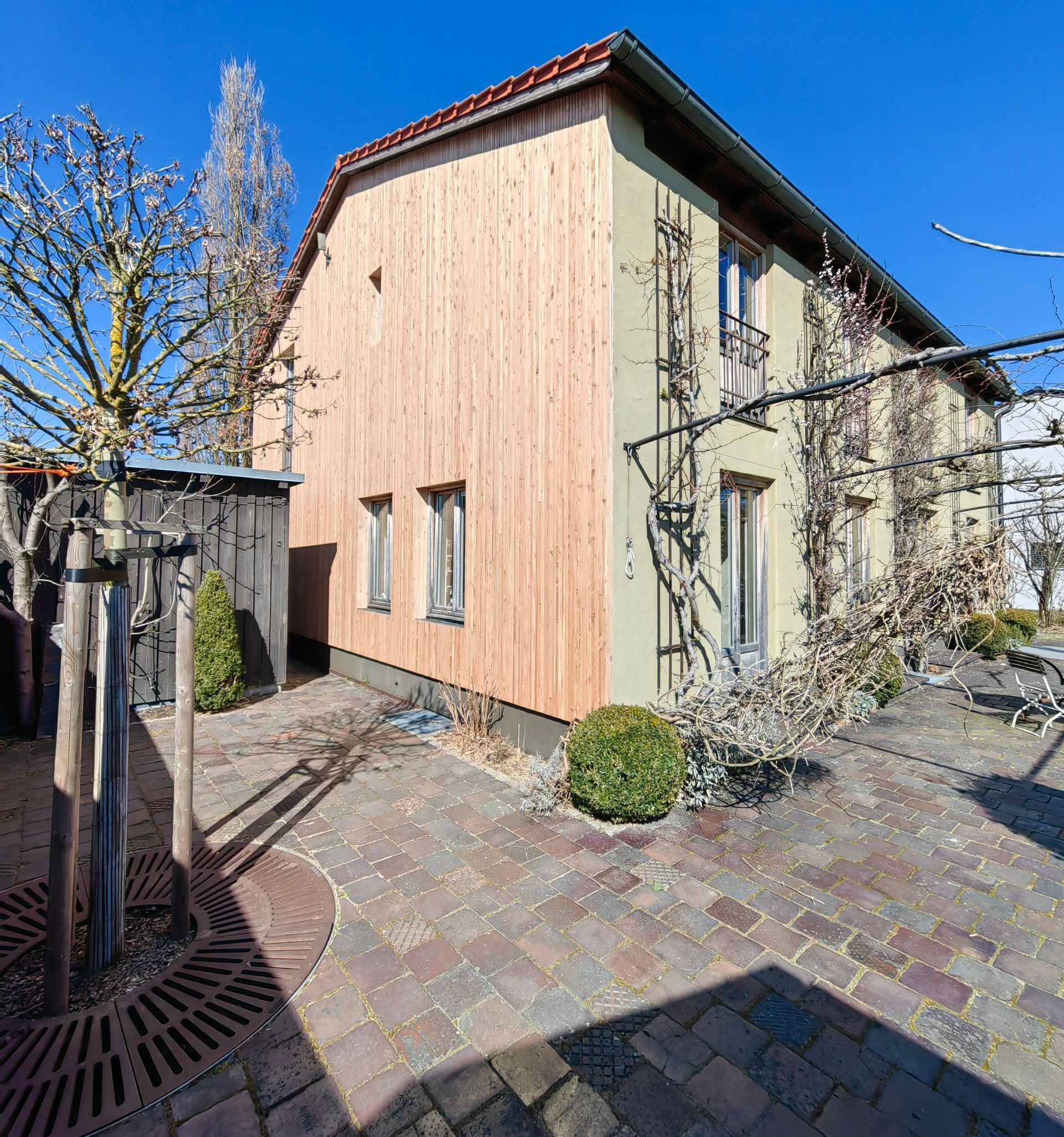Moderne Holzfassade aus vertikaler Lärchenverschalung an einem Bestandsgebäude - nachhaltige Sanierung durch Zimmerei in Bad Aibling