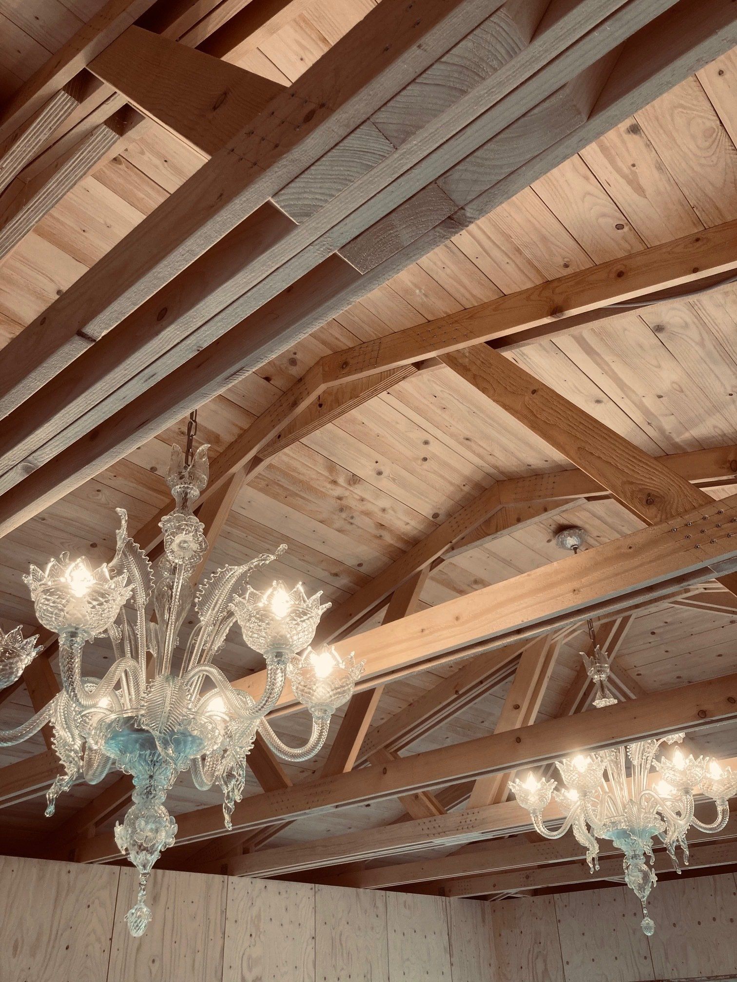 Detailaufnahme der Holzbalkendecke mit Kronleuchter - Kombination aus traditionellem Handwerk und zeitloser Eleganz gebaut in München