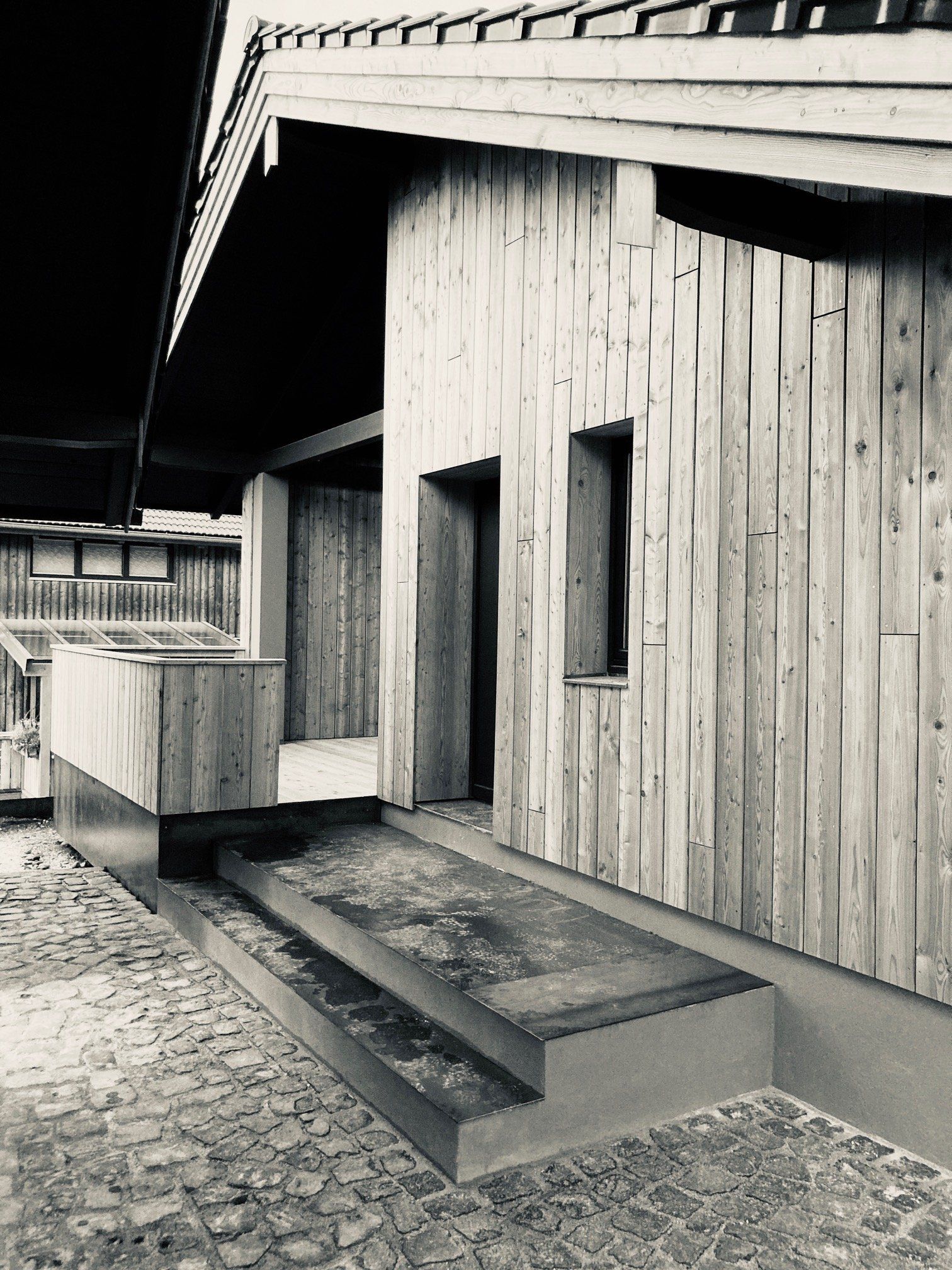 Sanierter Eingangsbereich mit klarer Holzstruktur - energieeffizient umgesetzt von bauwerk singer in Bad Aibling