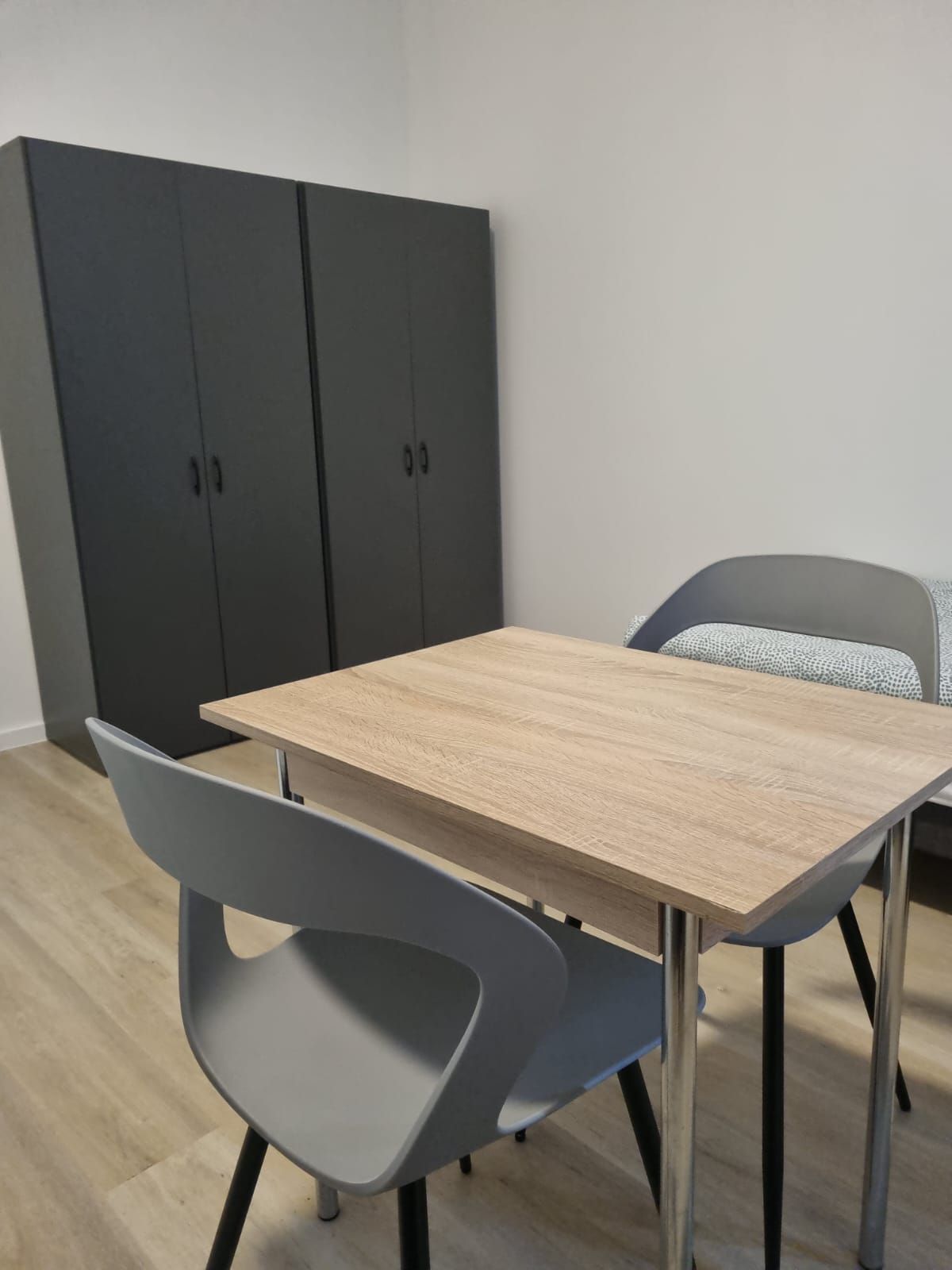 Appartment: Zimmer - Schrank, Tisch mit Stühlen