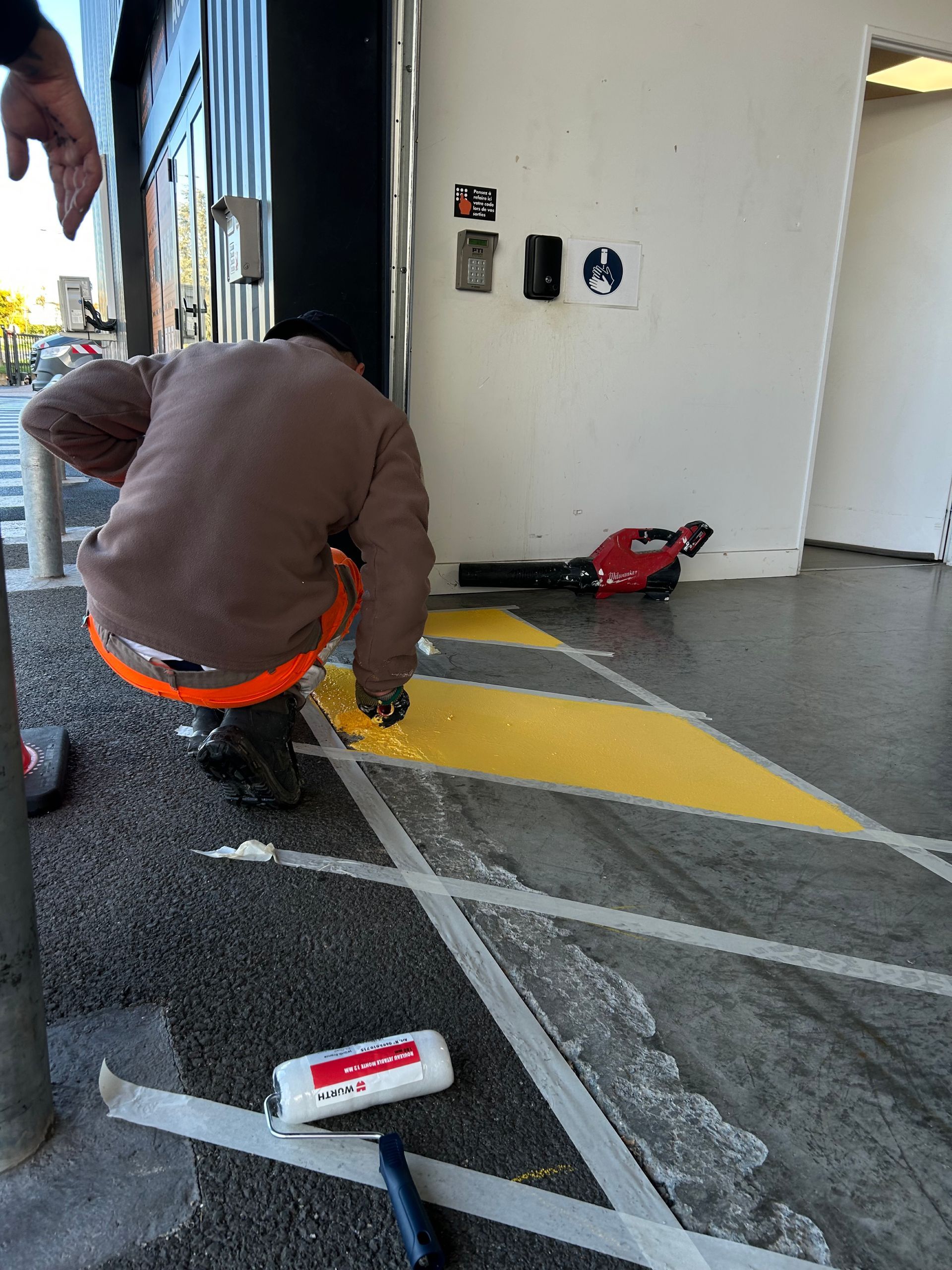 technicien marquage routier bande jaune et noir pour porte automatique