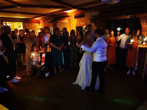 Brautpaar beim Hochzeitstanz vor Gästen in stimmungsvoller Atmosphäre