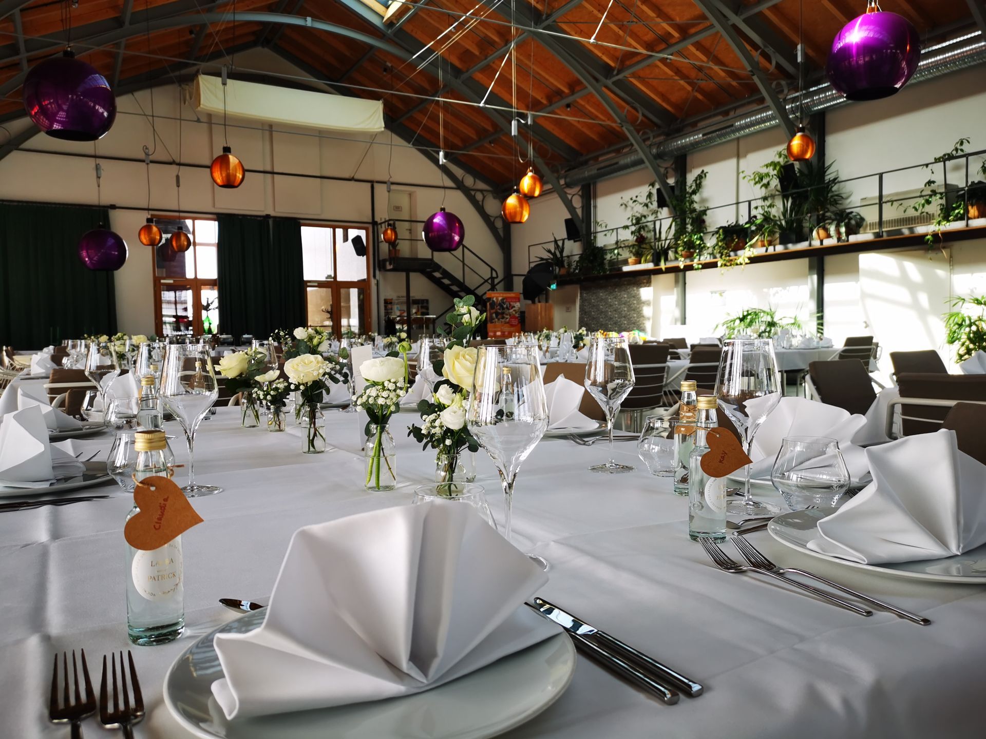 „Festlich gedeckte Hochzeitstische in der Orangerie Kehl mit Blumendekoration und Gläsern“