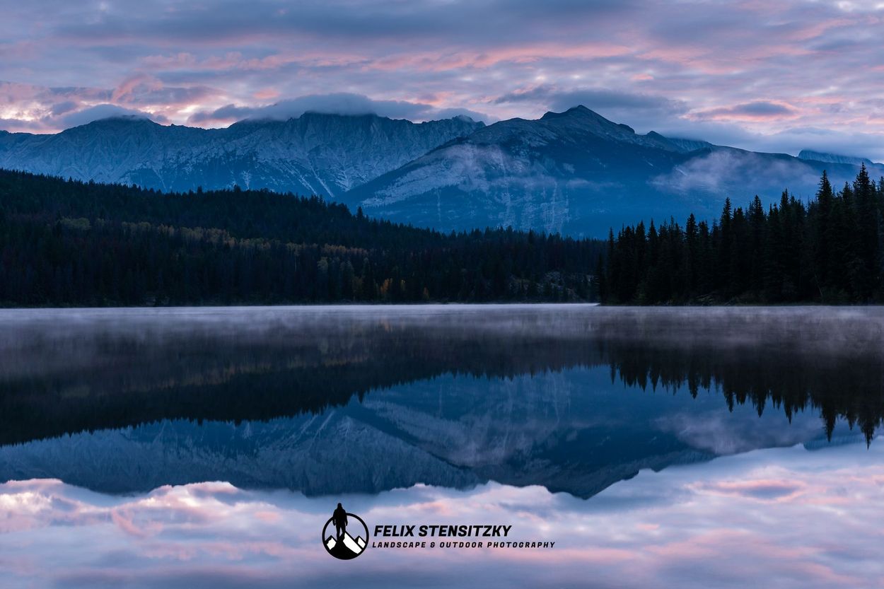 Landschaftsfoto von einem See in Kanada mit Bergen und farbigem Sonnenaufgang