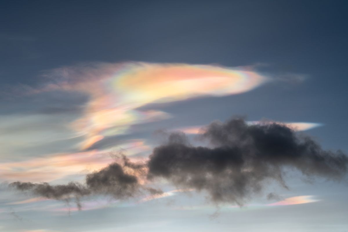 picture of colourful glowing polar stratospheric clouds with dark clouds in front