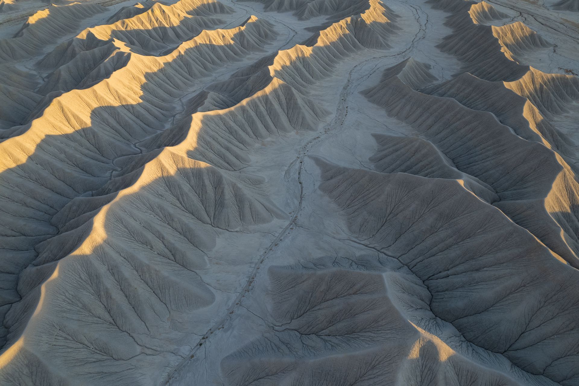 Luftaufnahme von Badland Formationen mit leuchtenden Hügelspitzen