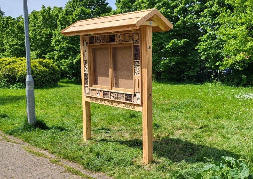 a bug hotel notice board made in cedar with wooden doors and bug hotel frame