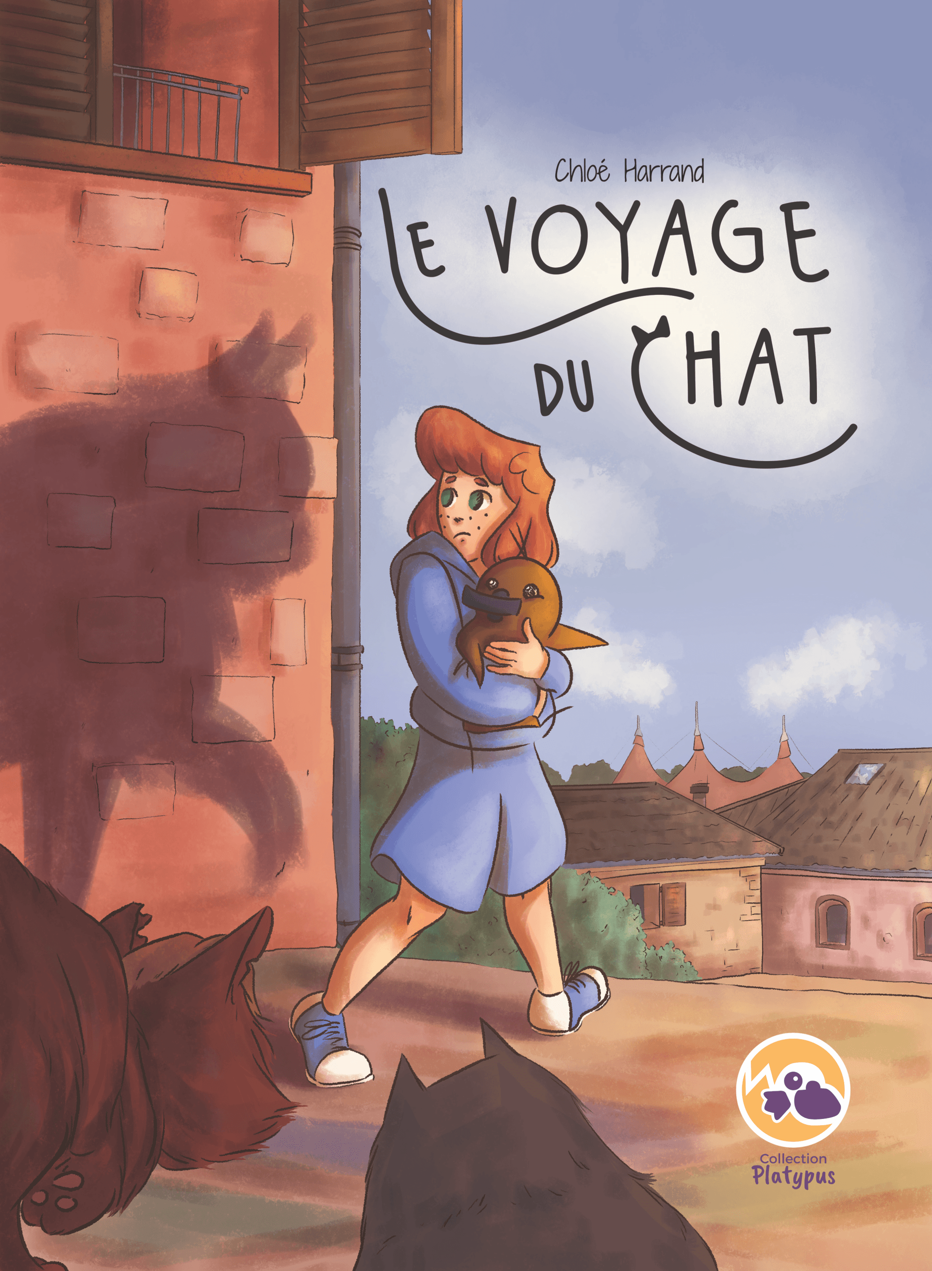 Couverture de la BD le voyage du chat un humain à l'ombre de chat tenant un doudou ornithorynque dans ses bras dans une rue d'une ville du Sud. 2 chats l'observant au premier plan