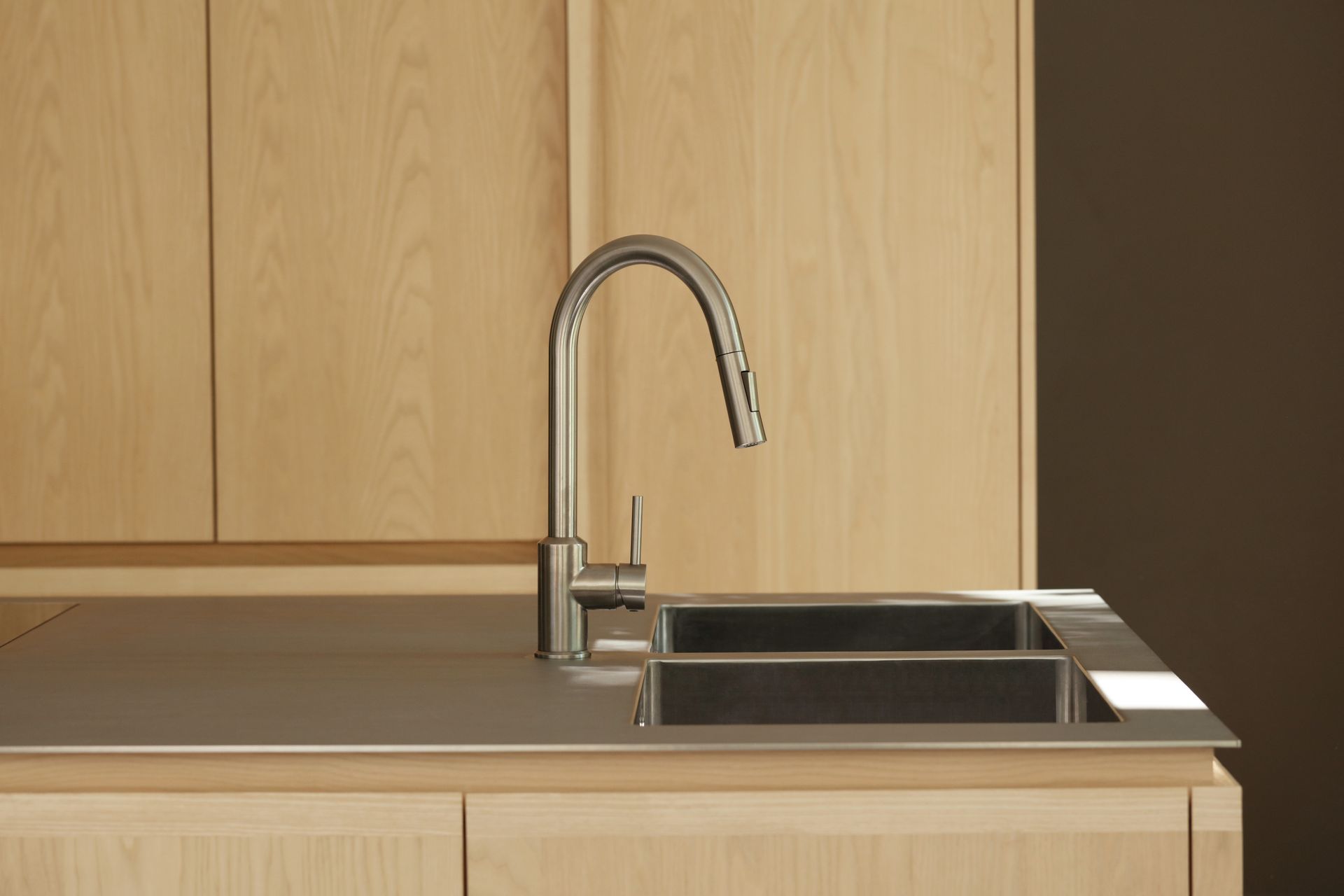 massive Edelstahl-Arbeitsplatte mit integriertem Spülbecken und massivem Wasserhahn – Küche Zehlendorf, ROY Design