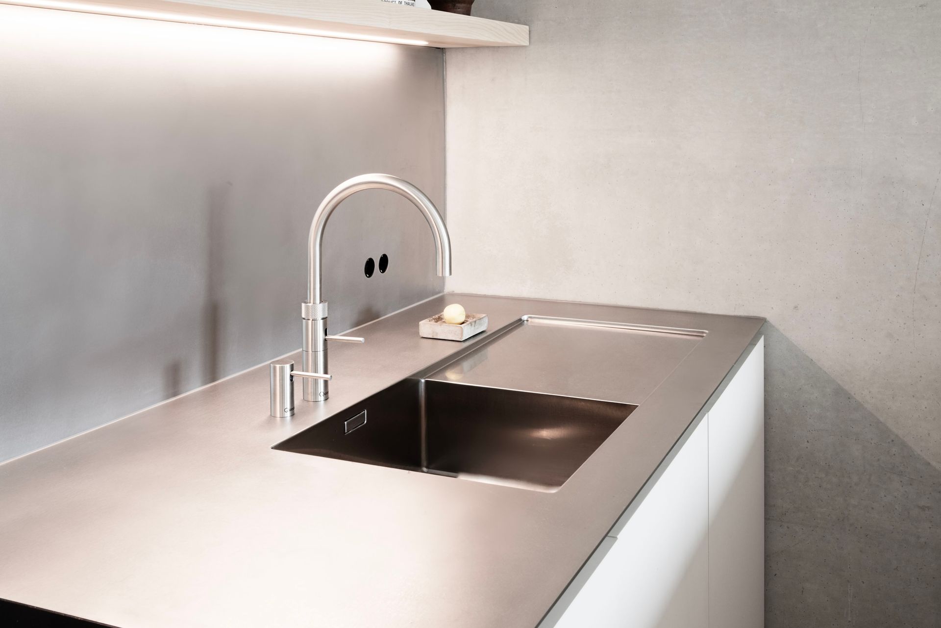 Detailansicht: Handgefertigte Edelstahlarbeitsplatte mit flächenbündigem Becken und Exzenterschliff – warmgewalztes Finish von ROY Design Berlin