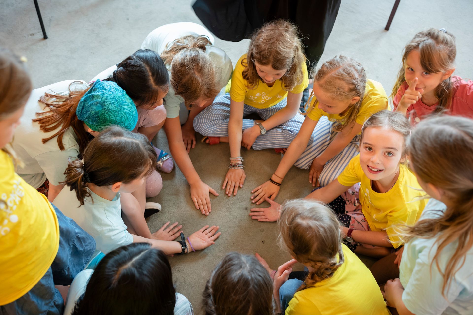 Kinder singen, z.T. mit Weihnachtsmützen.