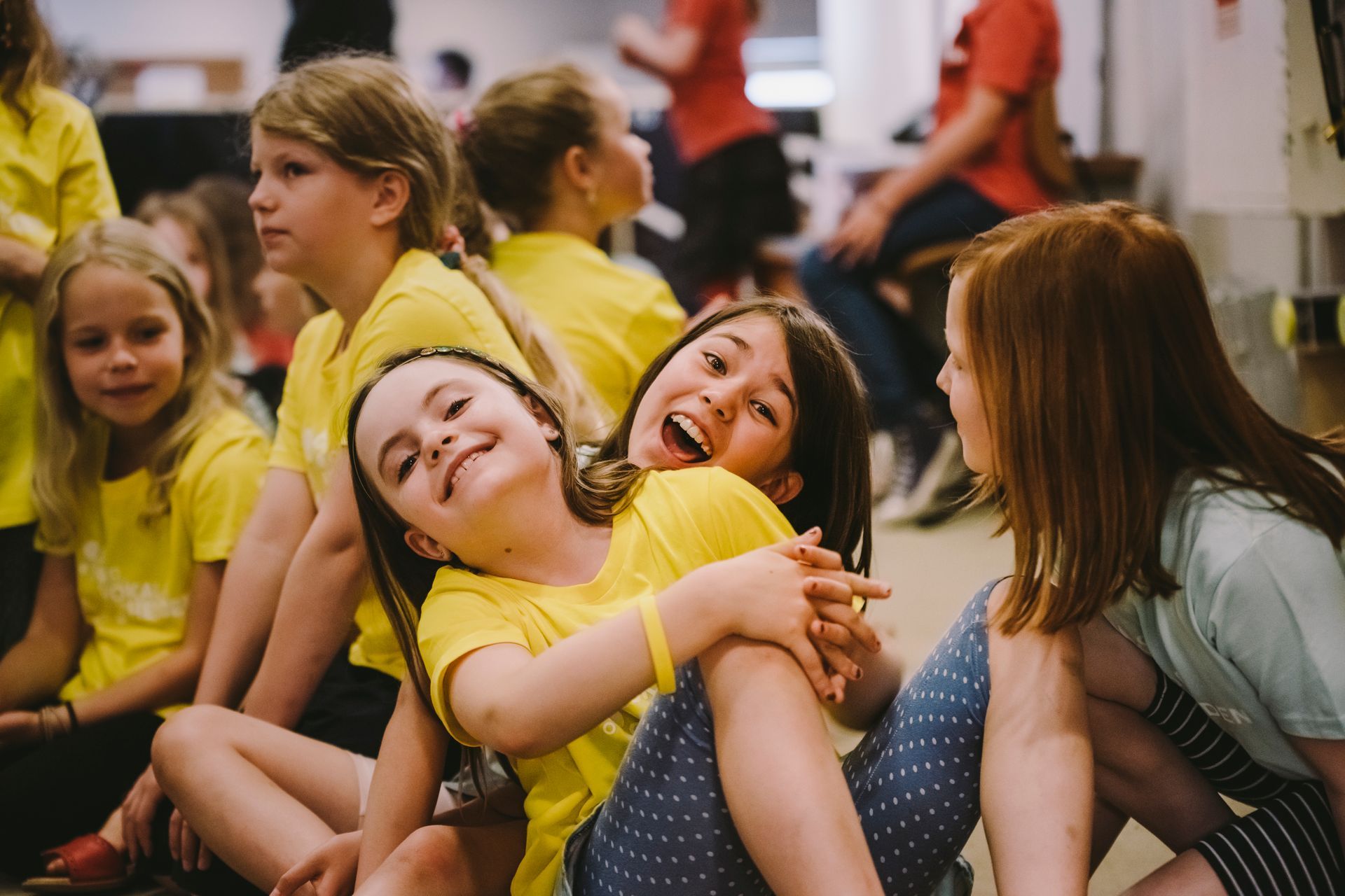Der Jugendchor sitzend beim Singen mit Simon Halsey vorne stehend als Dirigent.