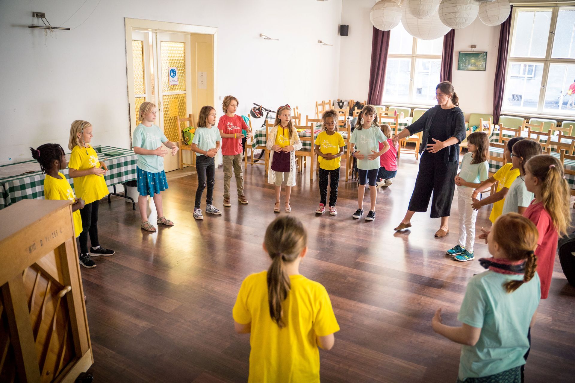Der Jugendchor sitzend beim Singen mit Simon Halsey vorne stehend als Dirigent.