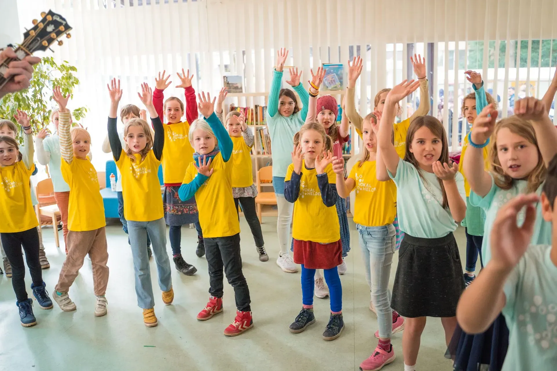 Kinder strecken die Arme und Hände nach oben im Rahmen einer Choreo.