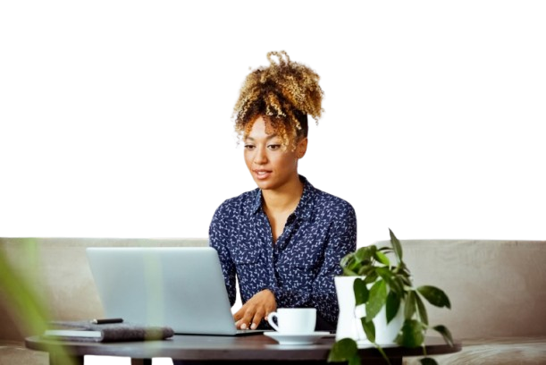 Joven negra sentada con un café sonriendo y viendo el ordenador