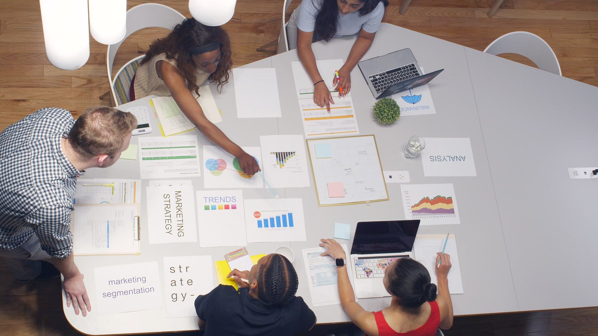 Profesionales alrededor de notas y gráficos creando una estrategia en Bienestar