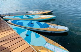 SUP Boards und weiteren Wassersport findet ihr bei Ahoi SUP 4 SUP-Boards im Wasser schwimmend an Holzsteg