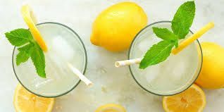 2 Cocktailgläser mit kalter Pomada mit Zitronen, Eiswürfeln, dekoriert mit Minze und Zitronenscheibe