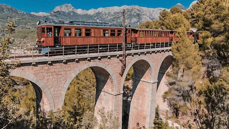 Tren de Soller fährt über ein Viadukt
