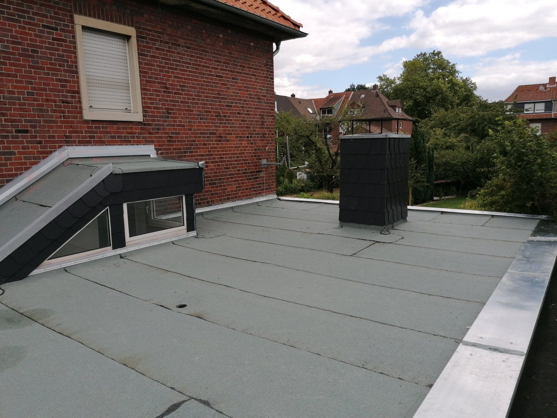 Flachdach Gefälledämmung Treppenaufgang Kamin Fenster Faserzement FZ Ablauf Gully Blau Schwarz Zink Dachrand