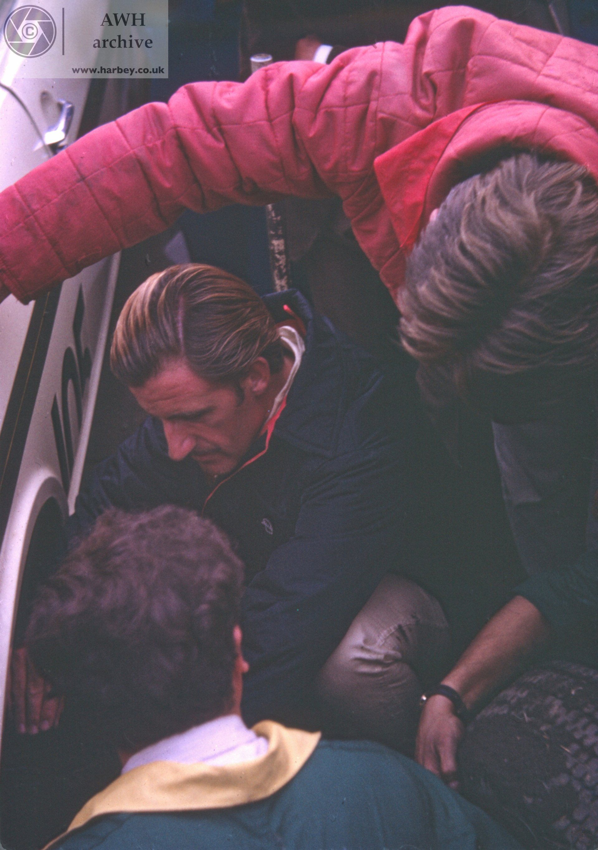 Graham Hill checking something out on the Lotus Cortina