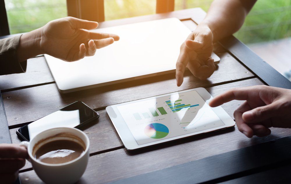 A picture of business peoples handspointing at a tablet discussing their marketing strategy