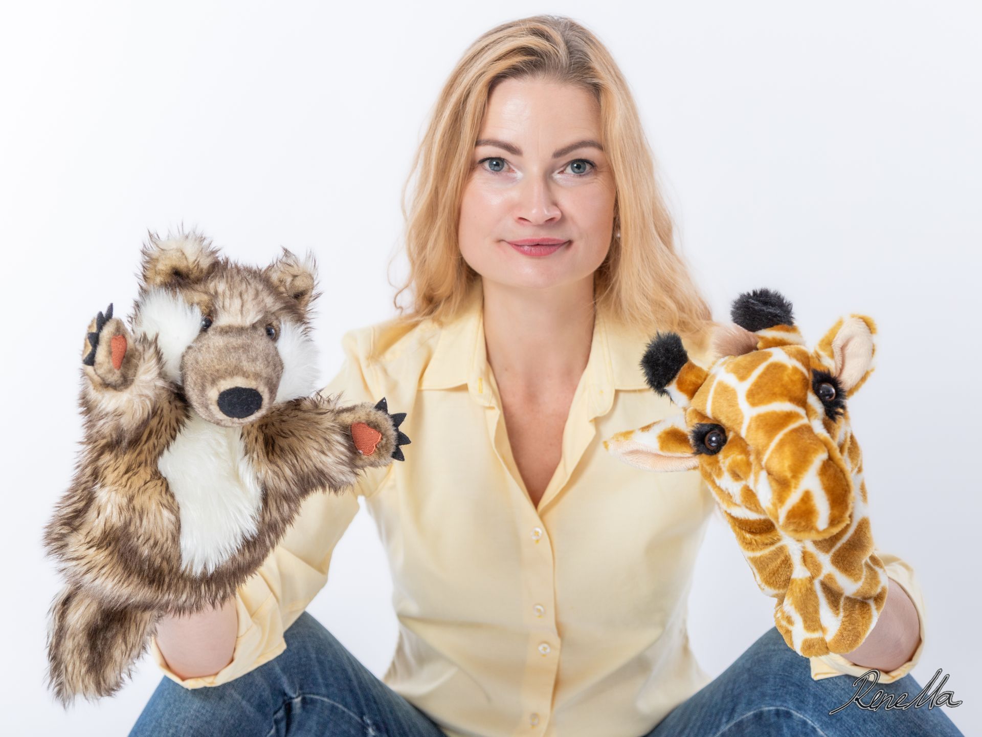 Frau mit Handpuppen die die Symboltiere der GFK Wolf und Giraffe darstellen
