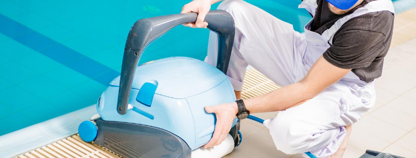 man with pool vacuum cleaning machine
