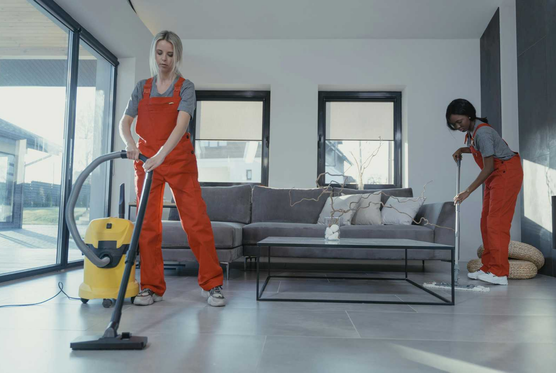 Zwei Putzkräfte die ein Wohnzimmer Reinigen