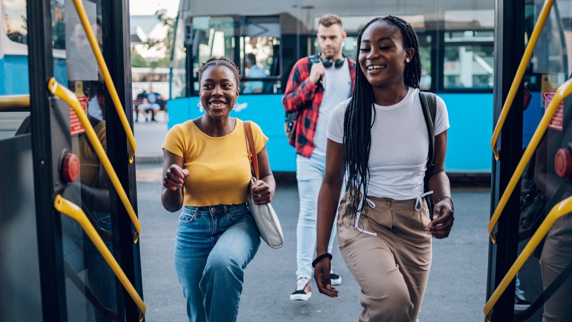 Learn more about transportation services through Southwest Georgia Regional Transit (SWGRT). Young adults boarding public transit buses, representing Southwest Georgia Regional Transit.