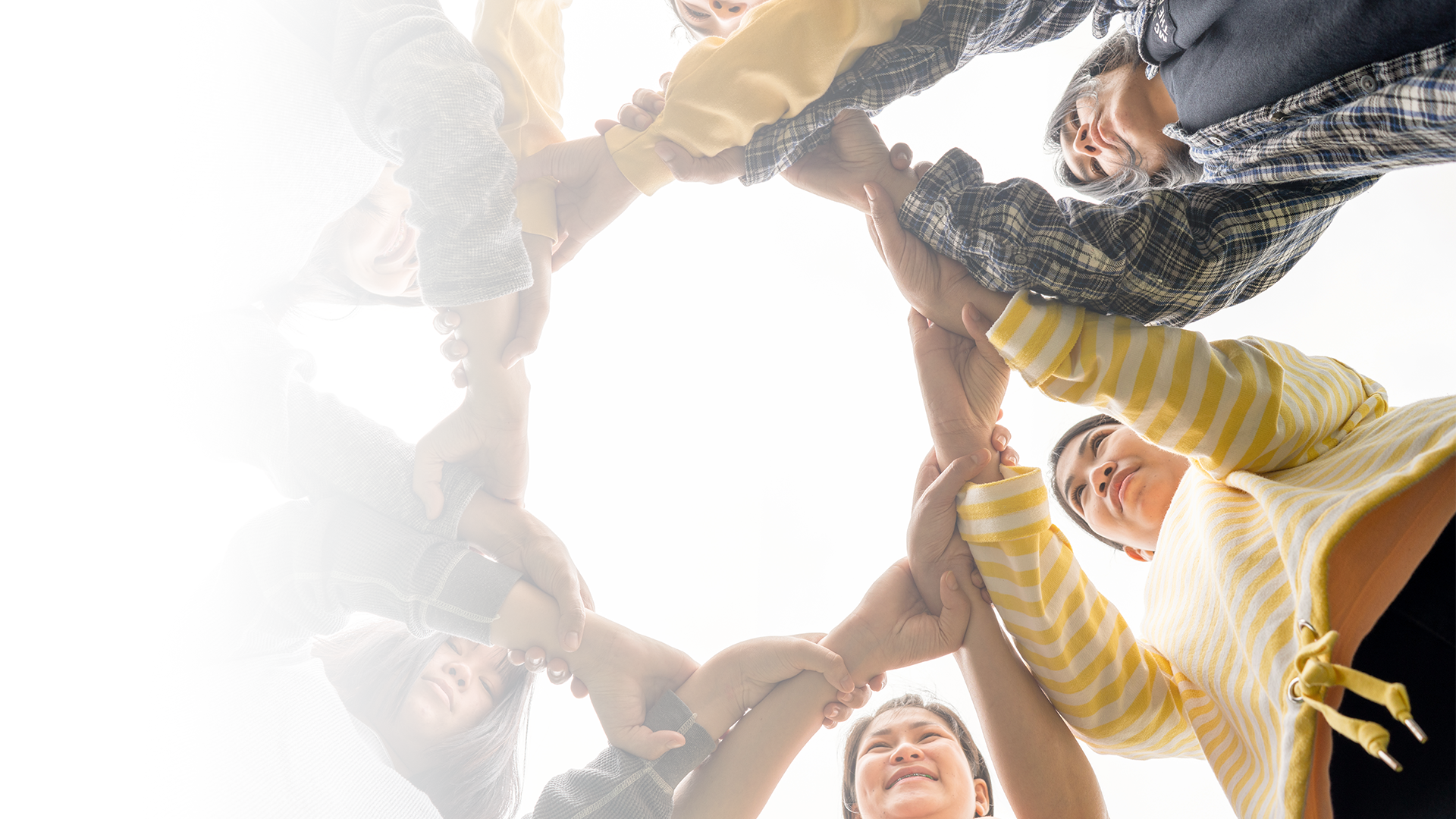 Explore how the Regional Partners Network fosters collaboration across Southwest Georgia. Group of people standing in a circle with joined hands, viewed from below, symbolizing partnership.