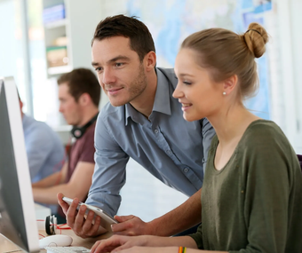 Hier gelangen Sie zu unseren Tableau Trainings Männliche Person unterstützt weibliche Person am Computer