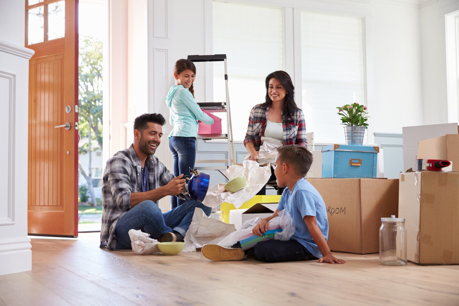 Family moving together boxes packed smiles on their faces