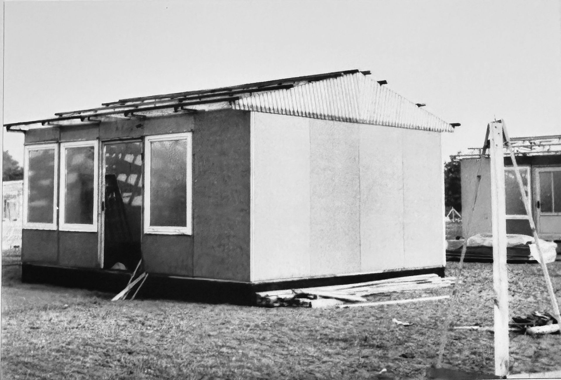 Rohbau Hütte, Wände und Fenster stehen, Dachstuhl ebenso, Dacheindeckung fehlt.
